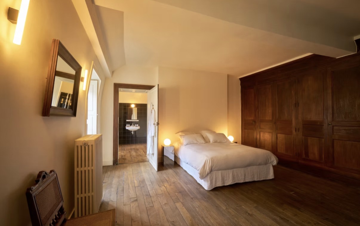 A spacious guest bedroom with a view into its bathroom