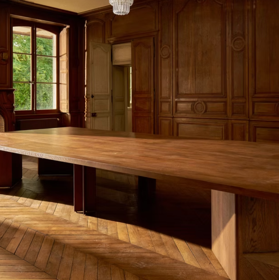 A long wooden table in a paneled room