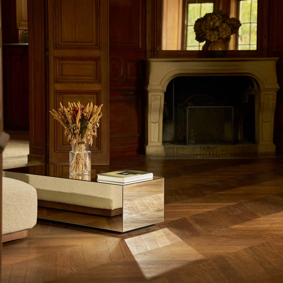 Flowers and warm light beside a château fireplace